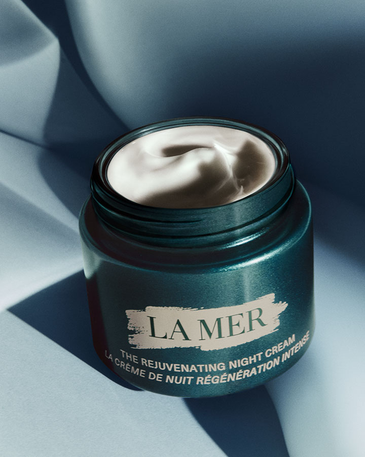 The Rejuvenating Night Cream with lid off showcasing product texture in a dramatically lit setting